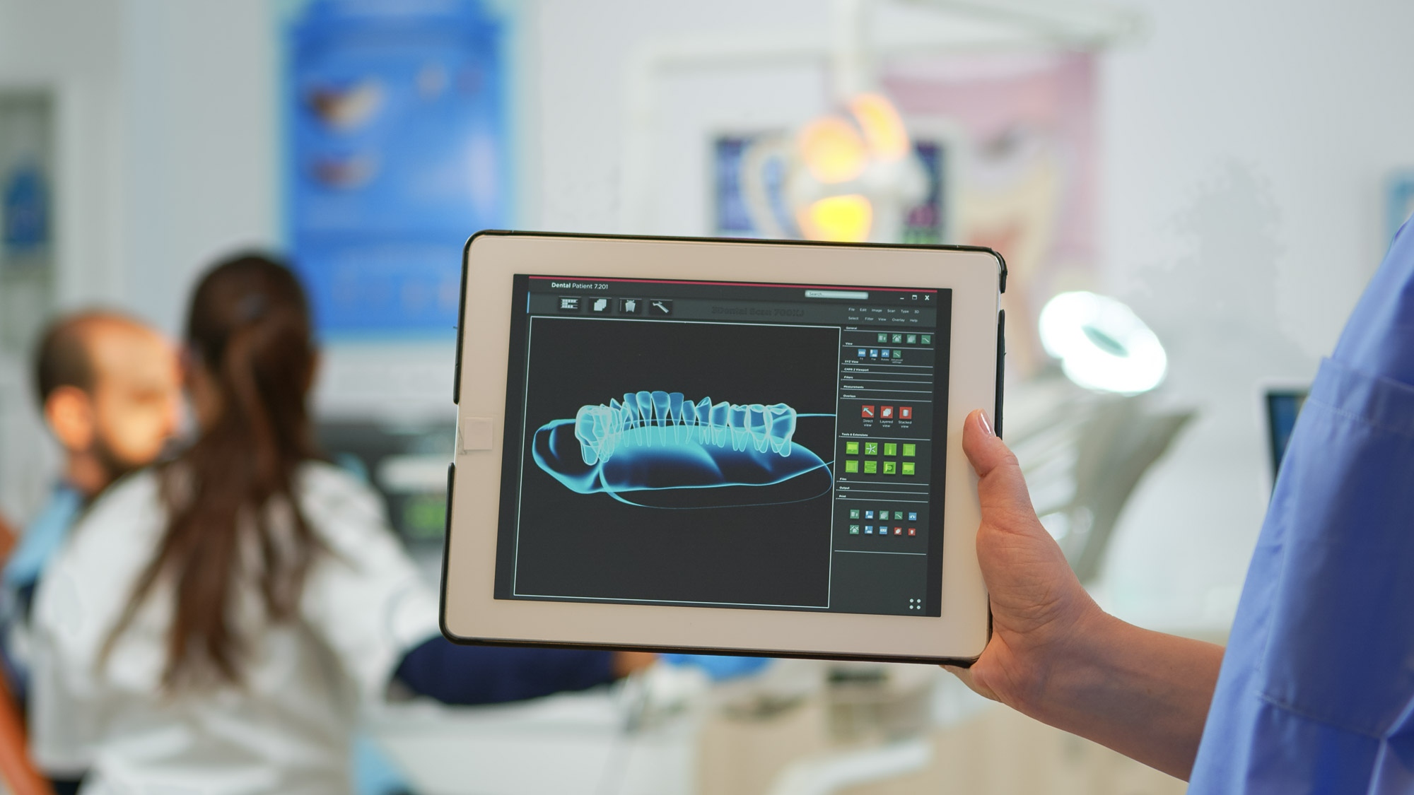 Close up dentist assistant holding tablet with digital dental fi