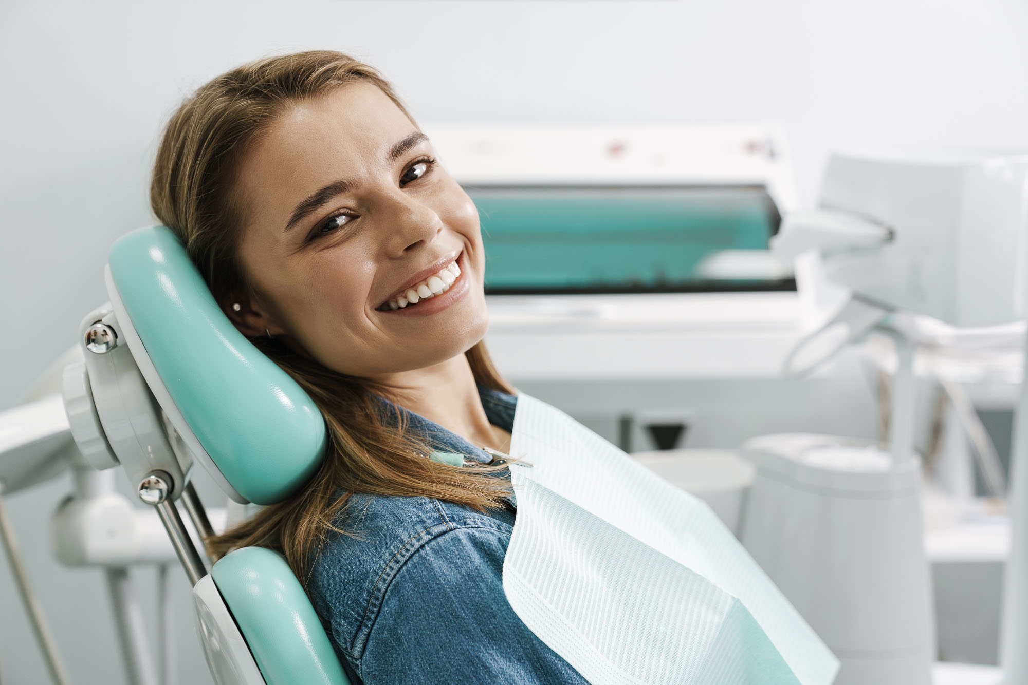 European young woman smiling while sitting in medical chair